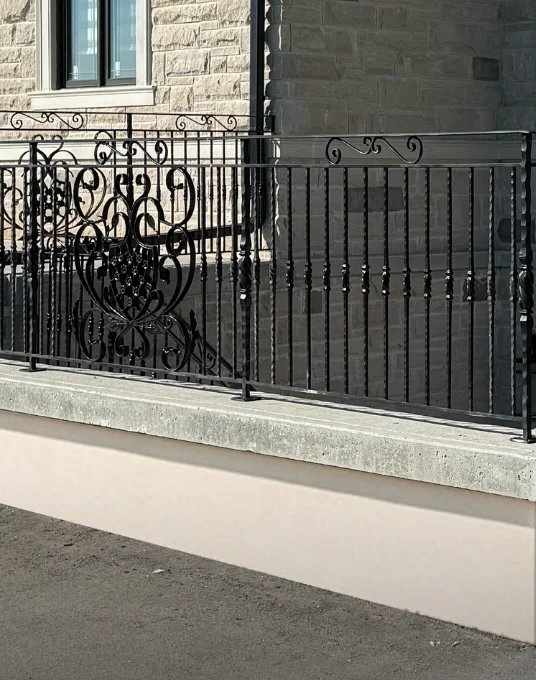 After: exposed concrete foundation finished with smooth parging under a wrought-iron railing